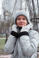 Girl 30 years old in warm clothes on the street in the park.
