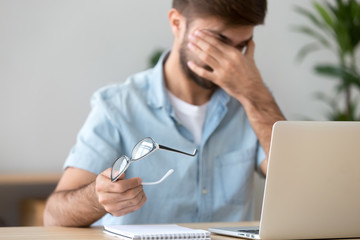 Man suffering from dry eyes syndrome after long computer work