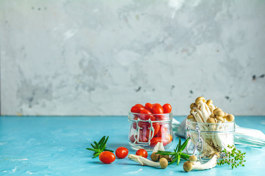 Clump of shimeji mushroom and cherry tomatoes in jars