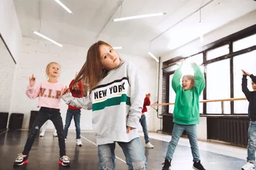 Cercles muraux École de danse The kids at dance school. Ballet, hiphop, street, funky and modern dancers over studio background. Children showing aerobic element. Teens in hip hop style. Sport, fitness and lifestyle concept.