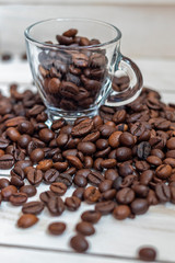 Cup and grain of coffee over white wooden background