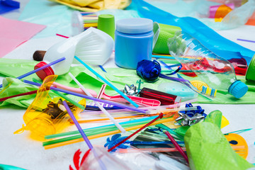 Fototapeta premium Close up of plastic bottle and packs lying near colorful straws