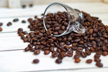 Fototapeta premium Cup and grain of coffee over white wooden background