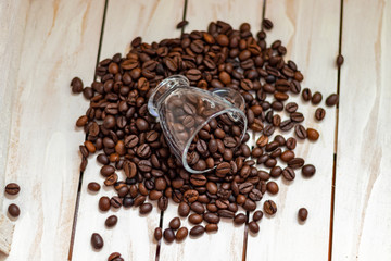 Cup and grain of coffee over white wooden background