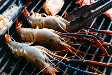 Barbecue Party - Closeup Chef cooking BBQ with shrimp grilled, pork and chicken's wing while summer vacation holidays in Thailand