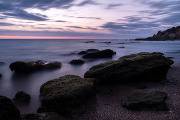 Fototapeta na wymiar Long exposure photography of the sea at the blue hour with rocks in Creek of Roche,Cadiz (Spain).