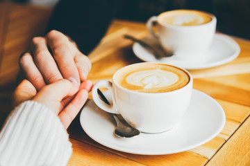 Two cup of cappuccino with latte art on wooden table.