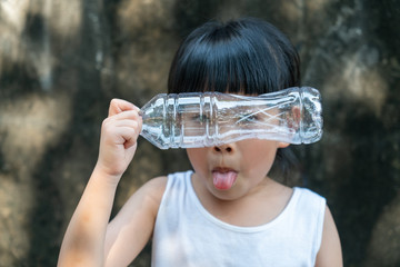 Child girl is acting with plastic bottle