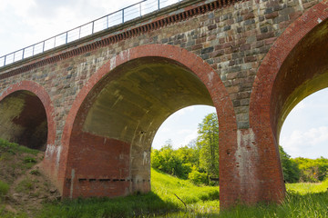 Old arch railway bridge at sunny summer day