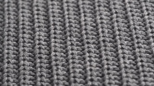 Wool background. Grey wool clothes texture closeup, dolly shot. Knitted soft gray merino wool macro shot. Natural woolen fabric. 4K UHD video footage. 3840X2160