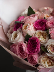 beautiful bouquet of different roses on a gray wall background
