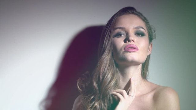 Sexy young woman portrait. Seductive young woman with long hair posing in spotlight. Slow Motion 4K UHD video footage. 3840X2160