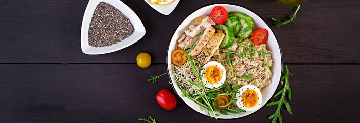 Fresh salad. Breakfast bowl with oatmeal, chicken fillet, tomato, lettuce, microgreens and boiled egg. Healthy food. Vegetarian buddha bowl. Banner. Top view