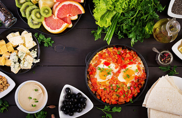 Turkish Breakfast -  shakshuka, olives, cheese and fruit. Rich brunch. Top view