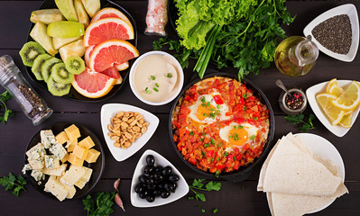 Turkish Breakfast -  shakshuka, olives, cheese and fruit. Rich brunch. Top view