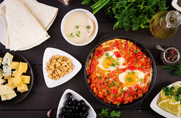 Turkish Breakfast -  shakshuka, olives, cheese and fruit. Rich brunch. Top view