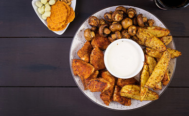 Fast food chicken nuggets with ketchup, french fries, baked mushrooms and cola. Top view