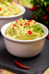 The traditional dish of Mexican cuisine. Guacamole. Avocado sauce with lime and chili. In a white...