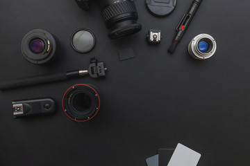 Fototapeta na wymiar Photographer workplace with dslr camera system, camera cleaning kit, lens and camera accessory on dark black table background. Hobby travel photography concept. Flat lay top view copy space
