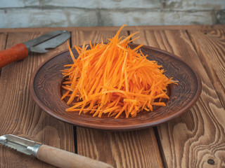 grated carrots on a ceramic brown plate standing