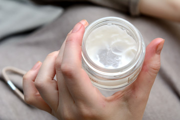 In the hands of a young woman a jar of cream. Concept - facial skin care