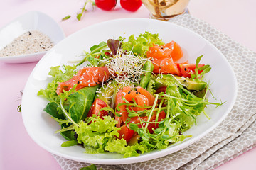 Diet menu. Healthy salad of fresh vegetables - tomatoes, avocado, arugula, seeds and salmon on a bowl. Vegan food.