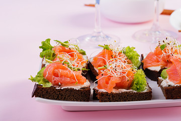 Salmon sandwiches with cream cheese and microgreen. Canape with salmon.