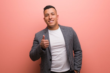 Young elegant latin man smiling and raising thumb up