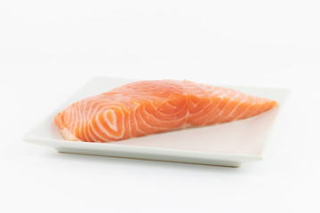 Salmone crudo su piatto e sfondo bianco