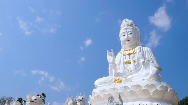 Time lapse of white big Guanyin statue with blue sky