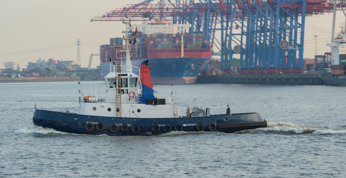 Hafenschlepper auf dem Weg zu einem Containerschiff um es zu schleppen 