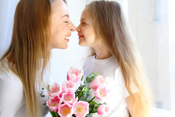 Cute little five year old girl giving her mom a present for mothers day. Adorable scene with daughter surprizing her mum. Close up, background, portrait.
