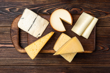 Cheese on dark wooden background.