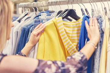 Happy woman shopping for clothes in store