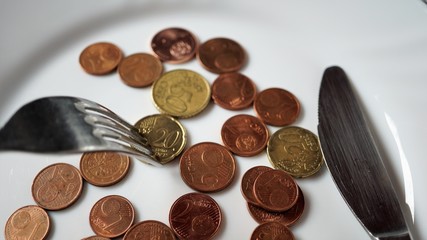Euro Cents Münzen auf einem Teller mit Besteck
