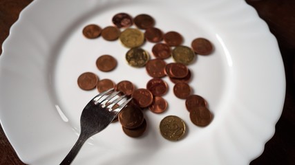 Euro Cents Münzen auf einem Teller mit Besteck