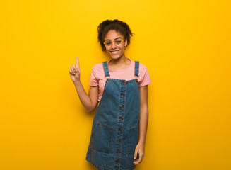 Young black african american girl with blue eyes showing number one