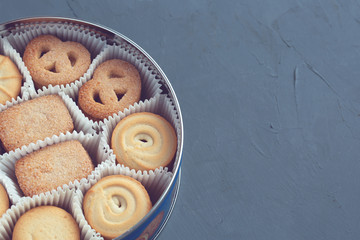 Cookies in a metal tin on a dark gray background. Close-up. Macro.