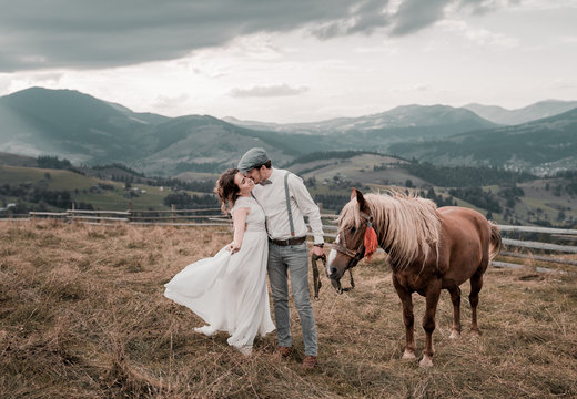vintage wedding of bride and groom on a ranch with a horse on peak hills