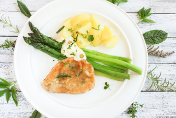 Teller frischer grüner Spargel mit Kartoffeln und Schnitzel von oben 