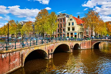 Foto op Aluminium Brug over kanaal in Amsterdam Nederland huizen rivier Amstel landmark oude Europese stad lente landschap. © Yasonya