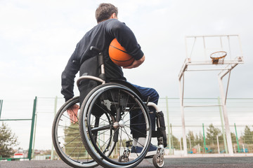 Young man in a wheelchair playing basketball.