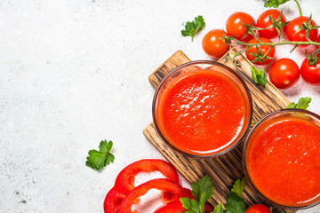Tomato vegetable juice in glass on white.