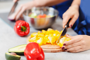 Woman hands cut yellow pepper for vegetable salad. Concept food workshop
