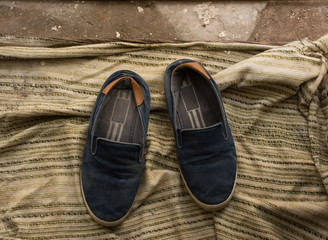 dirty old shoes on piece of cloth on ground