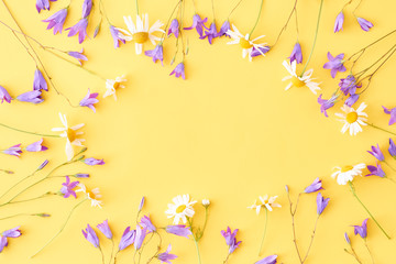 Flat lay composition with blue flowers on a yellow background