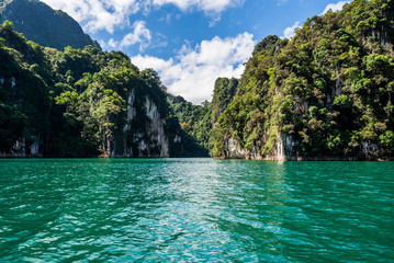 Fototapeta na wymiar Beautiful nature rock mountains cliff and blue emerald water color lake river with blue clear sky in Ratchaprapa Dam at Khao Sok National Park, Surat Thani Province, Thailand. Asia tourism location.