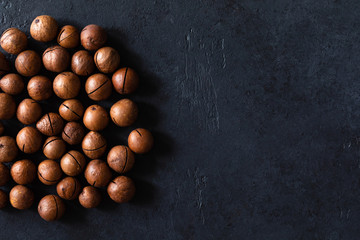 Top view of background texture of fresh natural unshelled raw macadamia nuts, full frame and flat lay