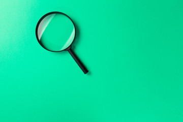 Magnifying glass on Mint background. Top view. Flat lay. Copy space. Minimal creative concept....