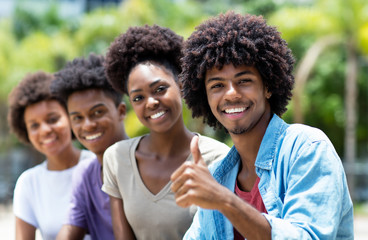 Happy african american man with group of young adults in line